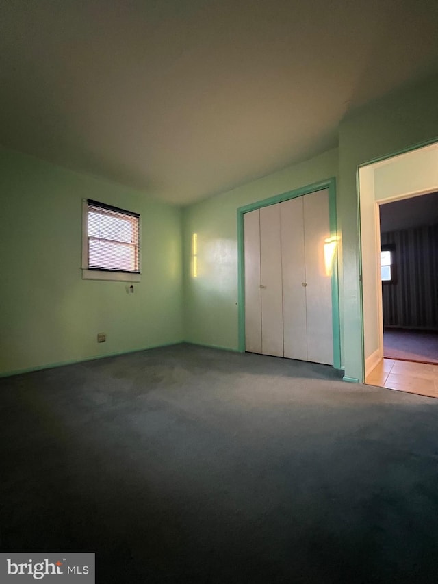 unfurnished bedroom with light carpet and a closet