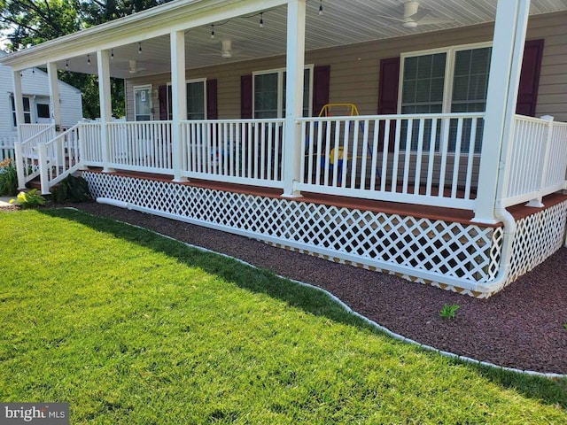 exterior space featuring a lawn, ceiling fan, and covered porch