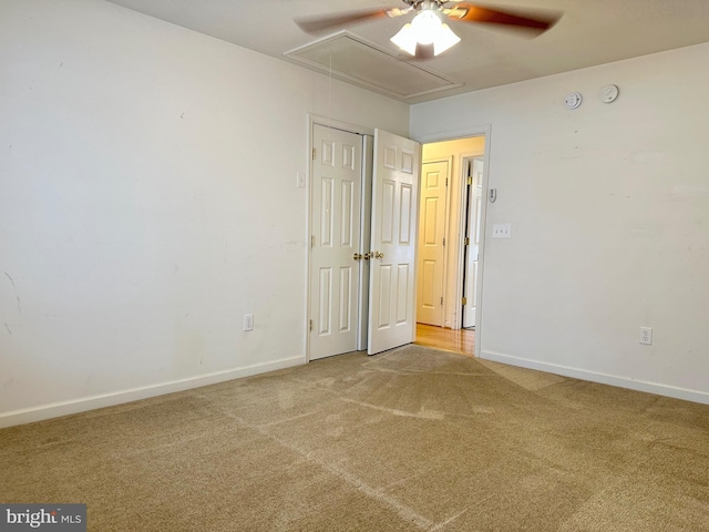 unfurnished room with attic access, carpet floors, and baseboards