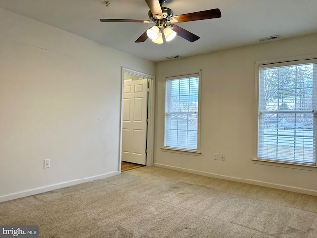 unfurnished room featuring baseboards, plenty of natural light, visible vents, and carpet flooring