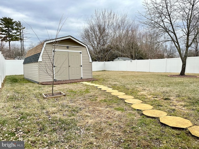 view of yard with a fenced backyard, an outdoor structure, and a storage unit