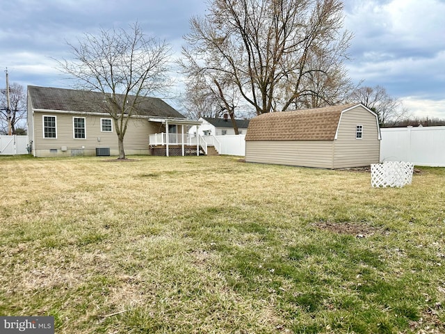 view of yard with central AC unit, a shed, a fenced backyard, an outdoor structure, and a wooden deck