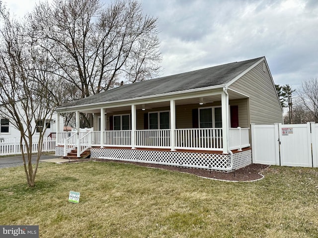 view of front of home with a porch, a front lawn, fence, and a gate