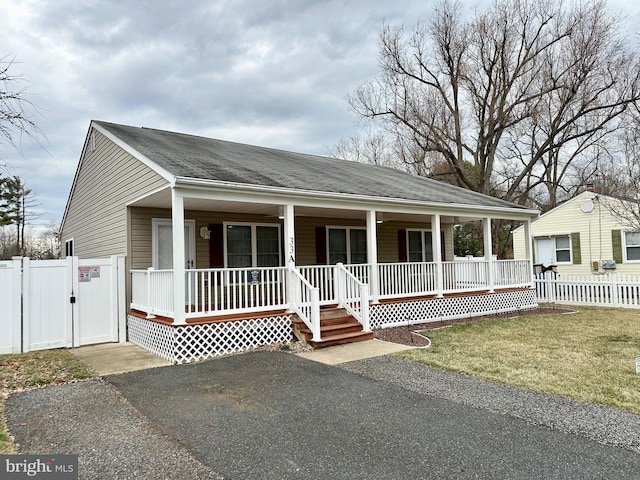 view of front of property featuring covered porch, a front yard, fence, and a gate