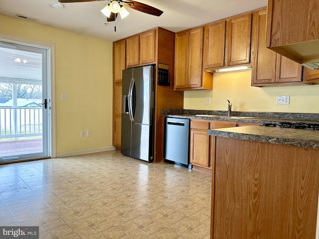 kitchen with light floors, stainless steel appliances, visible vents, brown cabinetry, and a sink