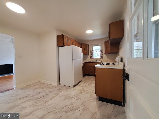 kitchen with range, sink, and white fridge