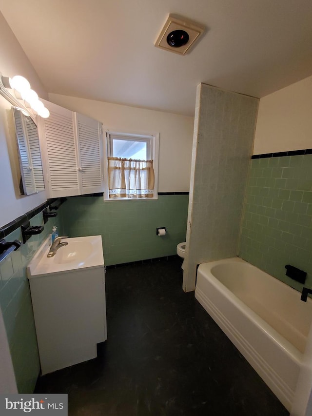 bathroom with vanity, tile walls, and toilet