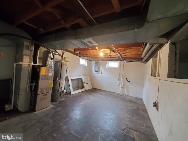 basement with gas water heater, heating unit, and electric panel