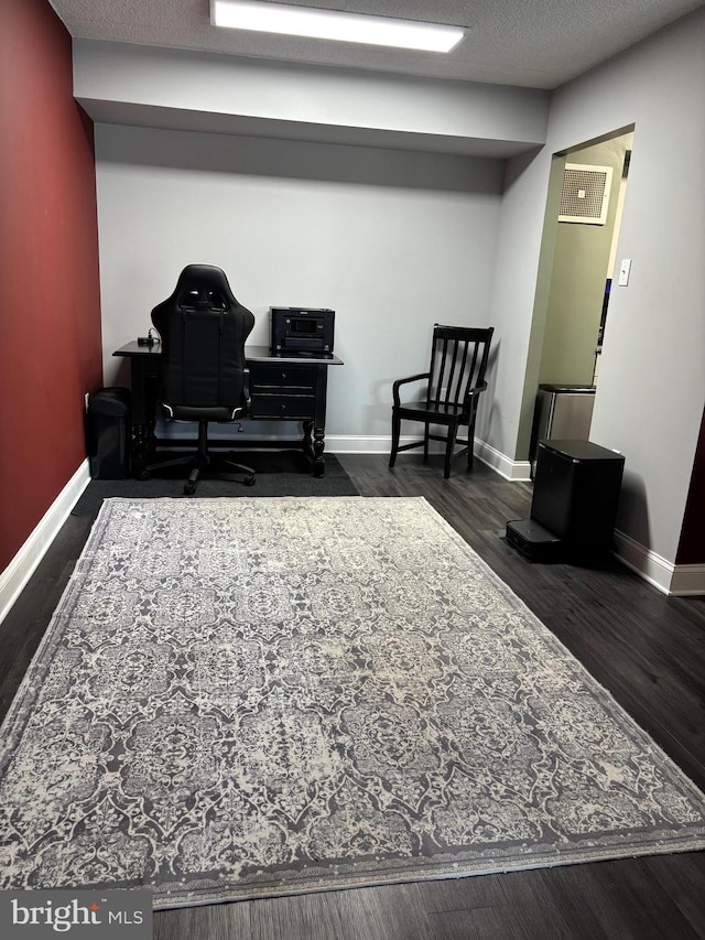 living area featuring visible vents, dark wood finished floors, a textured ceiling, and baseboards