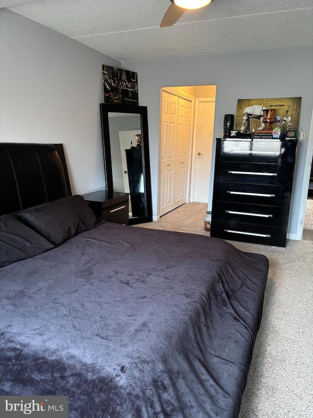 bedroom featuring carpet, ceiling fan, and a textured ceiling