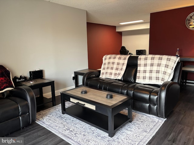 living area featuring a textured ceiling, baseboards, and wood finished floors