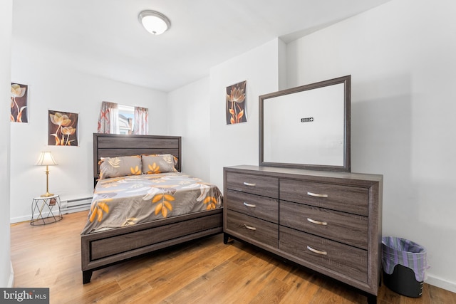 bedroom with a baseboard radiator and light wood-type flooring