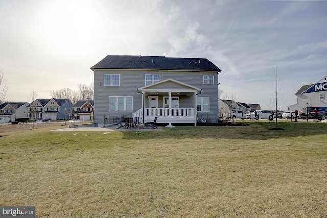 back of house with a yard, a patio area, and covered porch