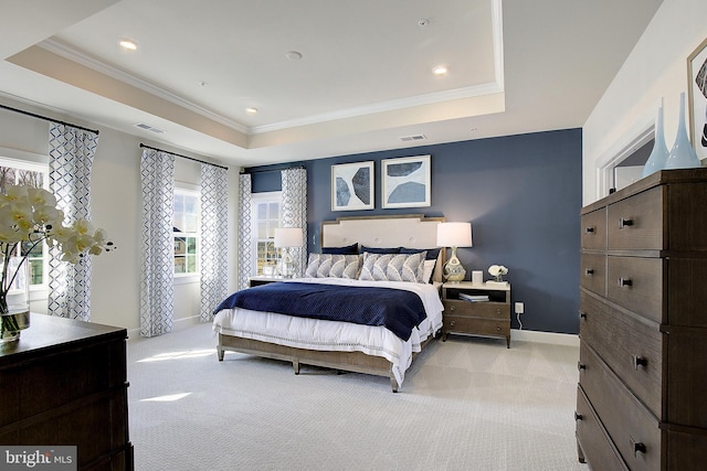 bedroom with light carpet, crown molding, and a raised ceiling