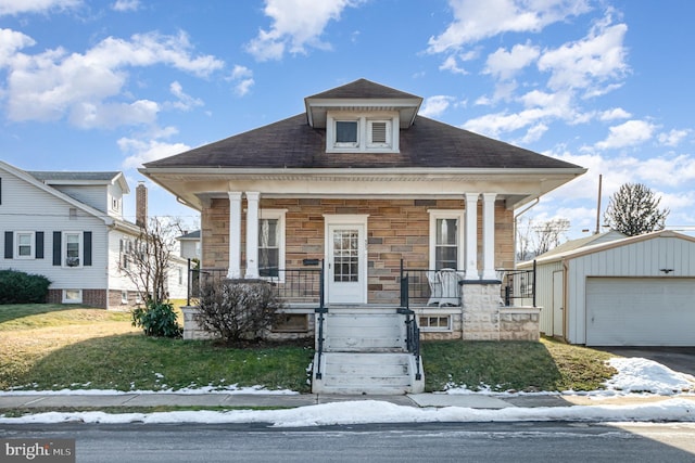 bungalow-style home with an outbuilding, a yard, a garage, and a porch