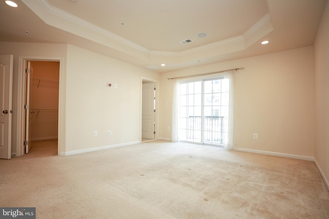 carpeted empty room featuring crown molding and a tray ceiling