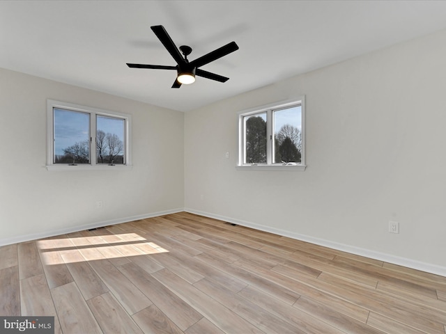 empty room with ceiling fan and light hardwood / wood-style flooring