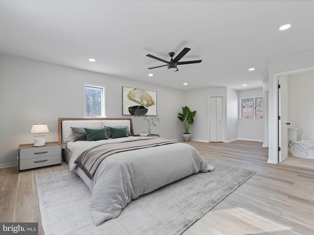 bedroom with light hardwood / wood-style floors, a closet, ceiling fan, and ensuite bathroom