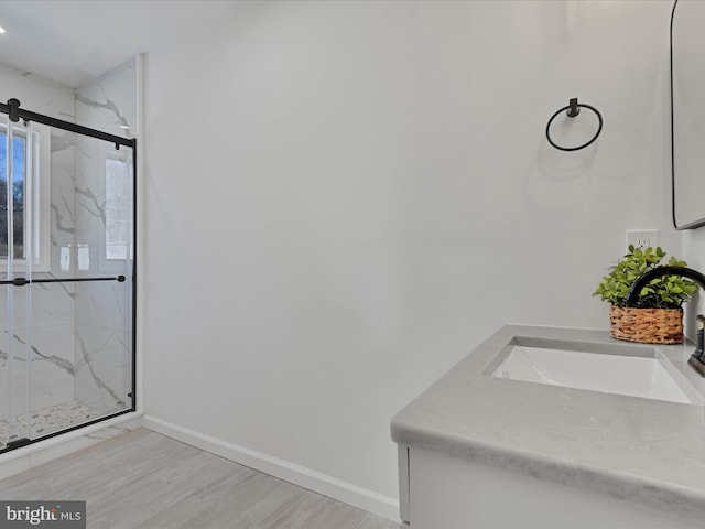 bathroom with a shower with door, vanity, and wood-type flooring