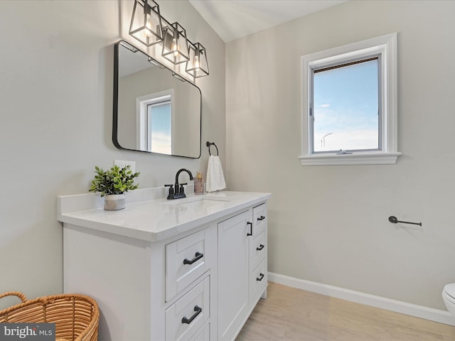 bathroom featuring vanity, hardwood / wood-style flooring, and toilet