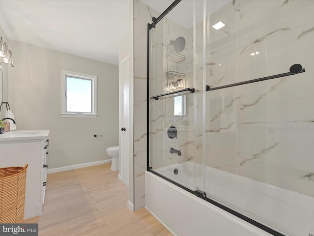 full bathroom with vanity, hardwood / wood-style flooring, enclosed tub / shower combo, and toilet