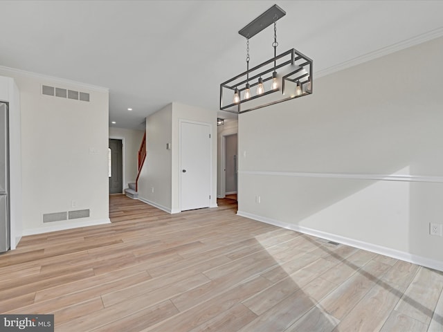 unfurnished dining area featuring crown molding and light hardwood / wood-style floors