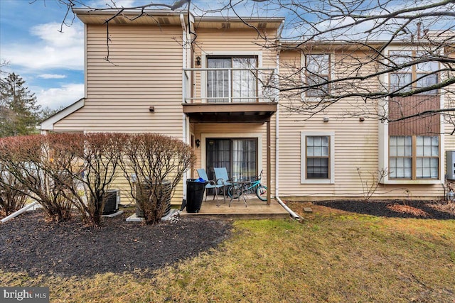 rear view of property with a yard, a patio area, and a balcony