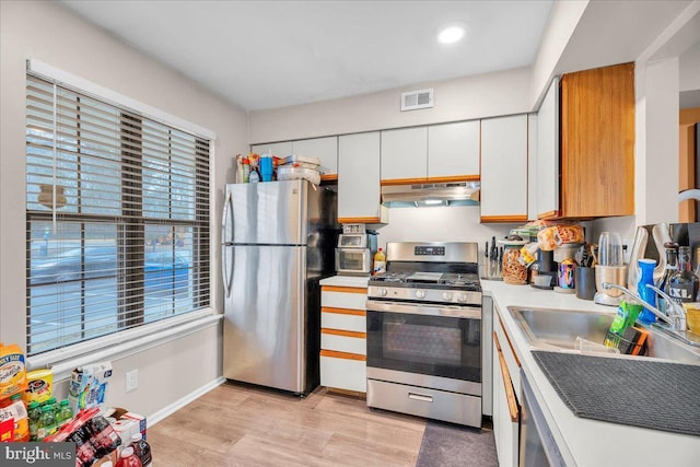 kitchen with sink, light hardwood / wood-style flooring, stainless steel appliances, and white cabinets