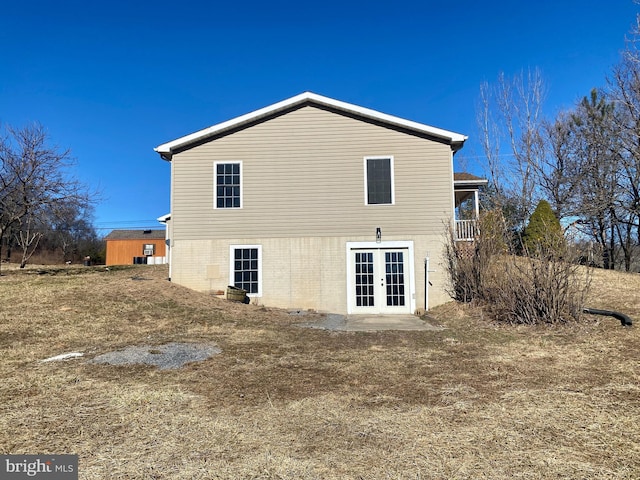 rear view of property with a lawn and french doors