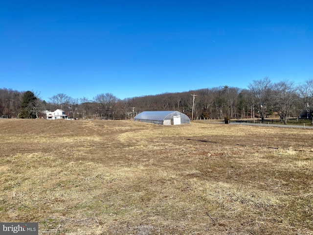 view of yard with an outdoor structure and a rural view