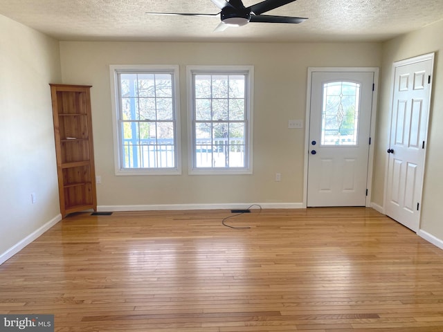 entryway featuring ceiling fan, light hardwood / wood-style flooring, and a textured ceiling