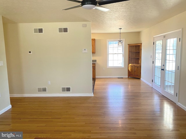 spare room with hardwood / wood-style flooring, ceiling fan, and a textured ceiling