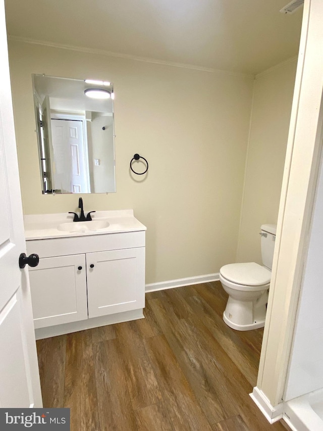 bathroom with wood-type flooring, vanity, and toilet