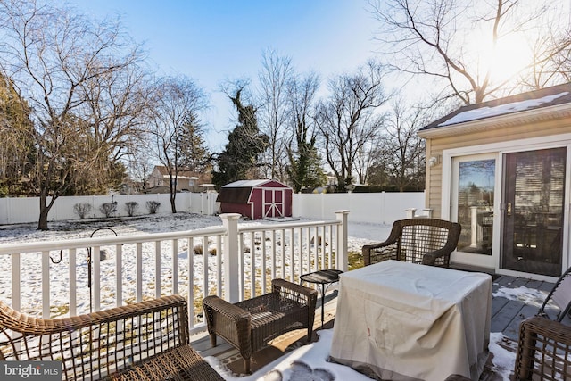 snow covered deck featuring a storage shed