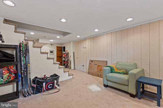 sitting room with light colored carpet and a textured ceiling