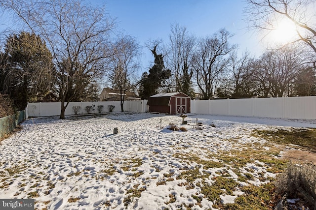 yard layered in snow featuring a storage unit