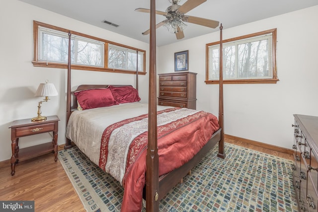 bedroom with visible vents, ceiling fan, baseboards, and wood finished floors