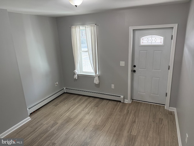 foyer entrance with baseboard heating and light hardwood / wood-style flooring