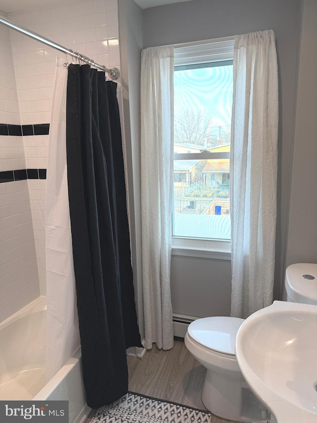 full bathroom featuring shower / tub combo with curtain, sink, a wealth of natural light, and hardwood / wood-style floors