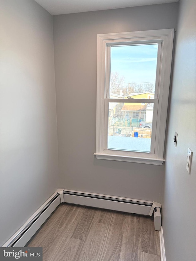 spare room with a baseboard radiator and light hardwood / wood-style flooring