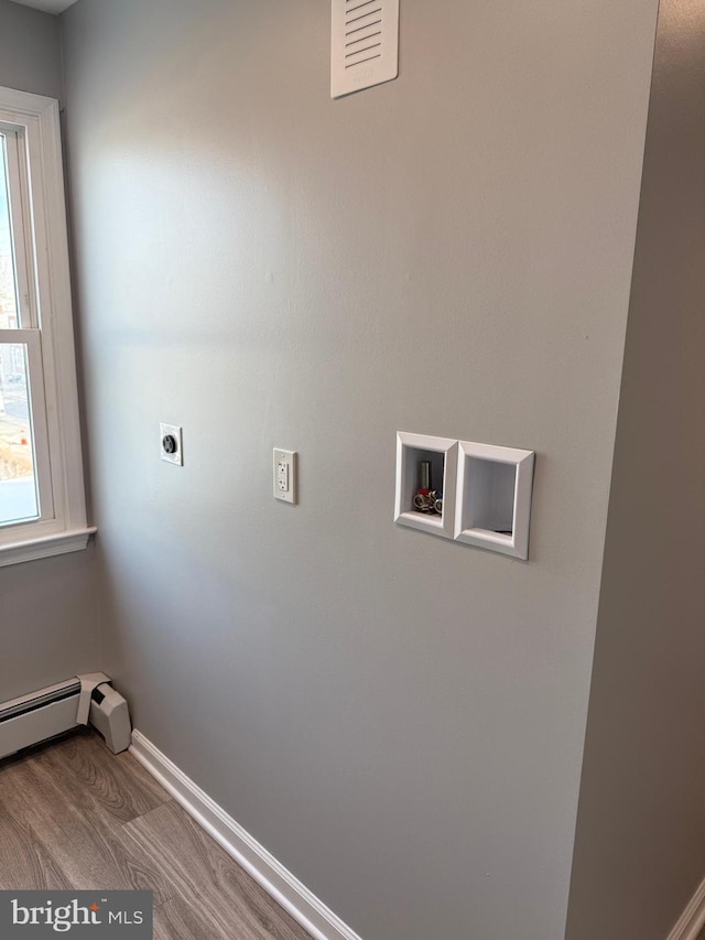 laundry area featuring electric dryer hookup, hookup for a washing machine, a baseboard radiator, and hardwood / wood-style flooring