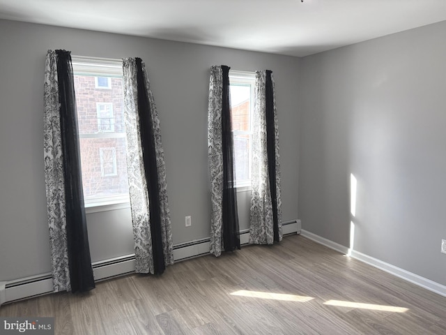 spare room with wood-type flooring and a healthy amount of sunlight