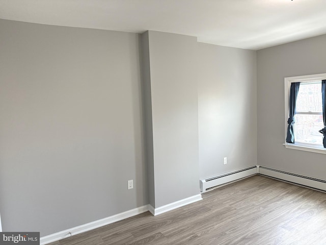 unfurnished room with light hardwood / wood-style flooring and baseboard heating