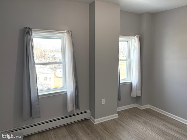 spare room with hardwood / wood-style flooring and baseboard heating