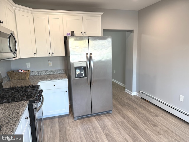 kitchen with stainless steel appliances, light wood-type flooring, white cabinets, and baseboard heating