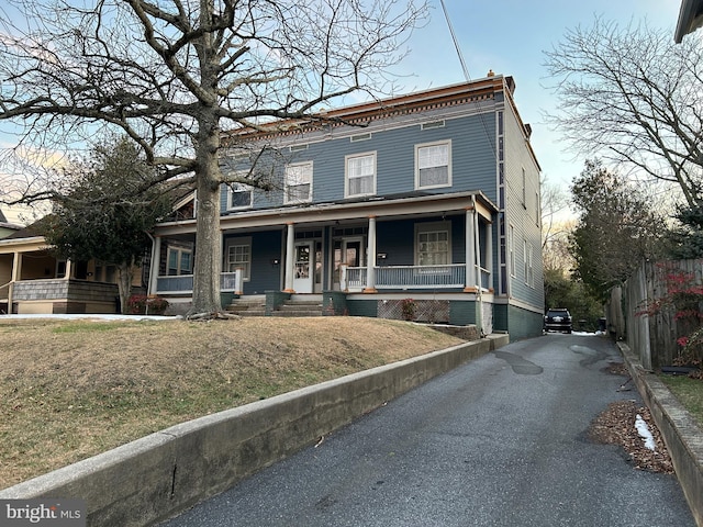 view of front facade with a porch and fence