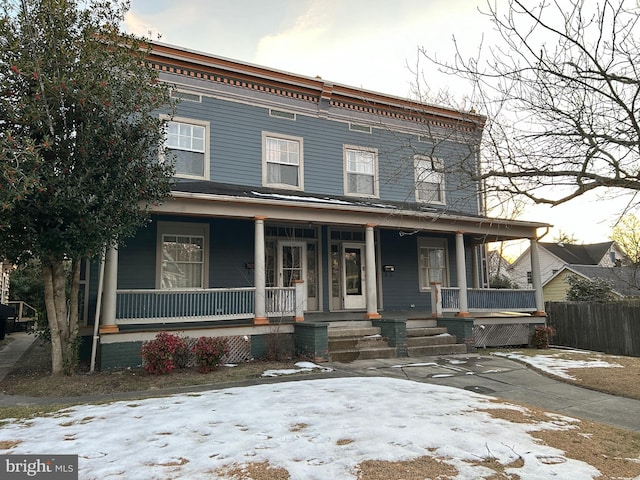 view of front of home featuring covered porch and fence