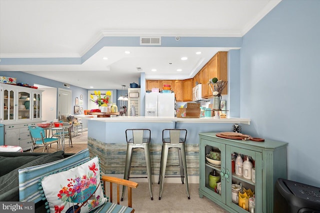 kitchen featuring white appliances, ornamental molding, kitchen peninsula, and light colored carpet