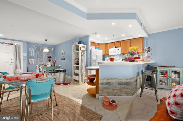 kitchen with light tile patterned flooring, pendant lighting, kitchen peninsula, crown molding, and white appliances