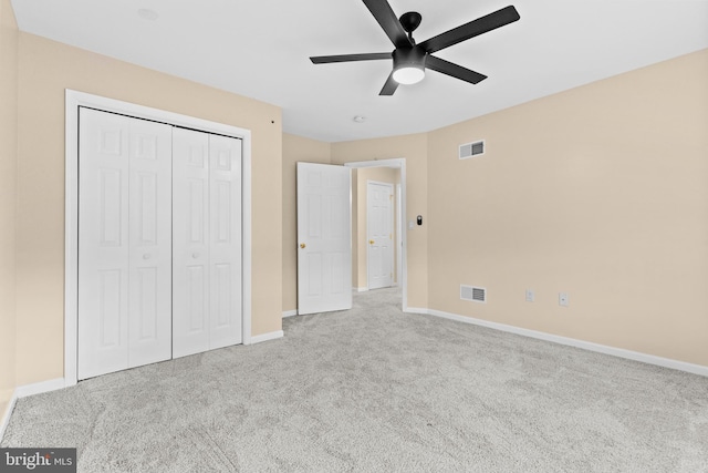 unfurnished bedroom with light carpet, ceiling fan, and a closet